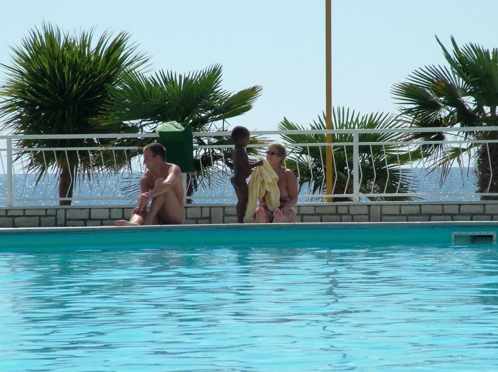Photo of naturists in an outdoor pool - Living in harmony with nature is the primary goal of the naturist and nudist lifestyle