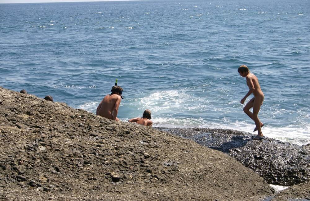 Leaning Against Hit Rocks pics - In nudism, people are equal to one another
